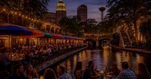 People dining along the San Antonio River Walk representing local food and travel experiences